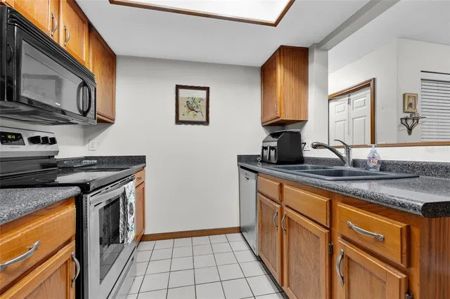 a kitchen with stainless steel appliances granite countertop a stove a sink and a microwave