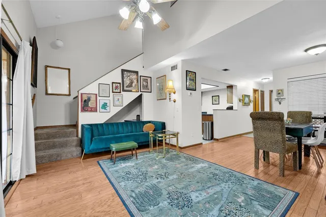 a living room with furniture and a dining table with wooden floor