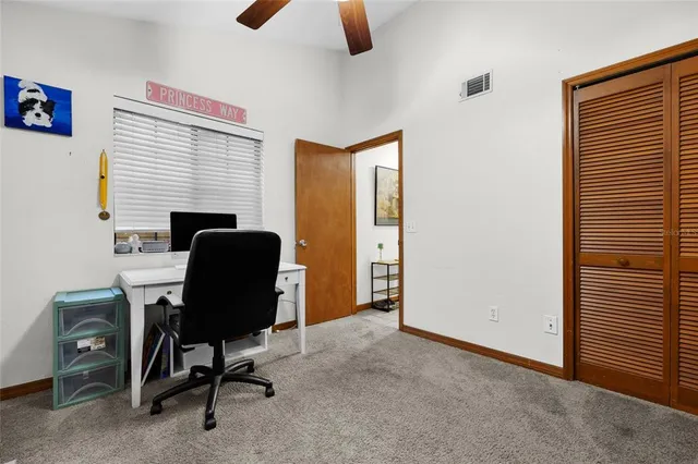 a view of a workspace with furniture and a window