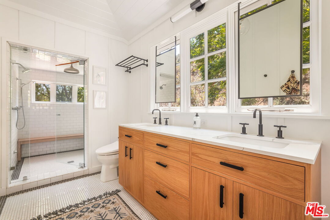 2015 Nichols Canyon Road Los Angeles, CA 90046 - Photo 15 of 27 a bathroom with a granite countertop sink a toilet a mirror and shower