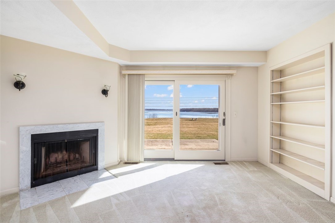 4496 Post Road, Unit 3 Warwick, RI 02818 - Photo 7 of 44 Living room with wood burning fireplace and water view.