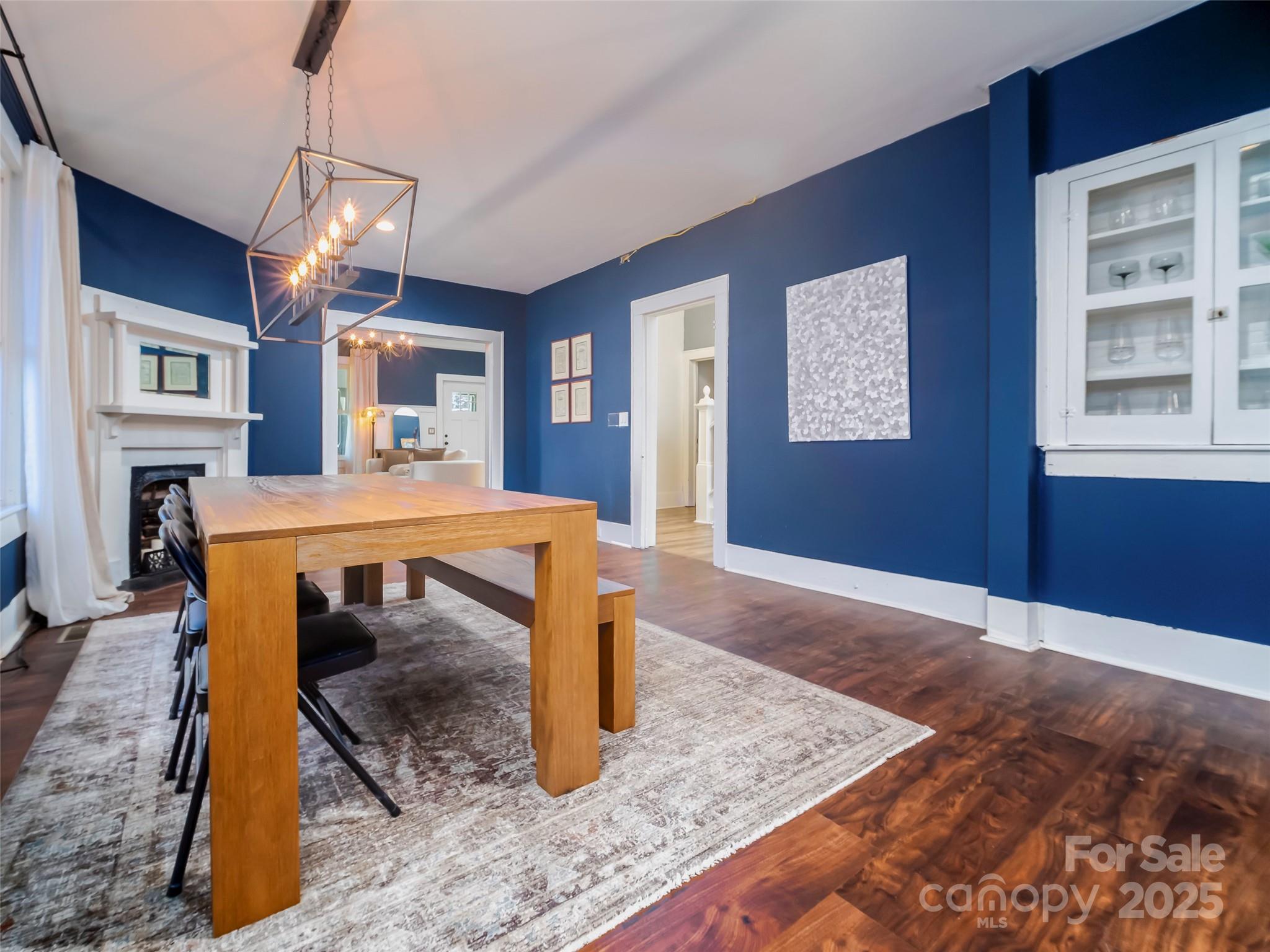 525 West 2nd Avenue Gastonia, NC 28052 - Photo 11 of 39 a dining room with wooden floor a chandelier a wooden table and chairs