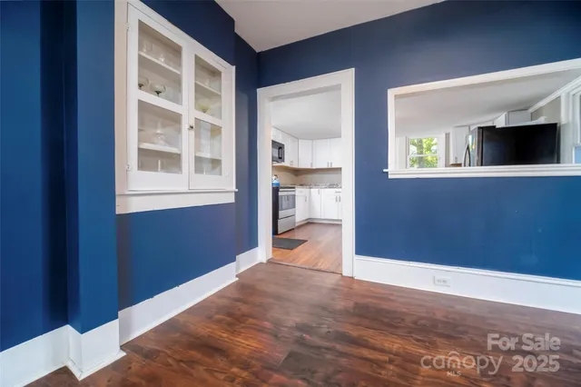 a kitchen with granite countertop wooden floors stainless steel appliances a sink and a window