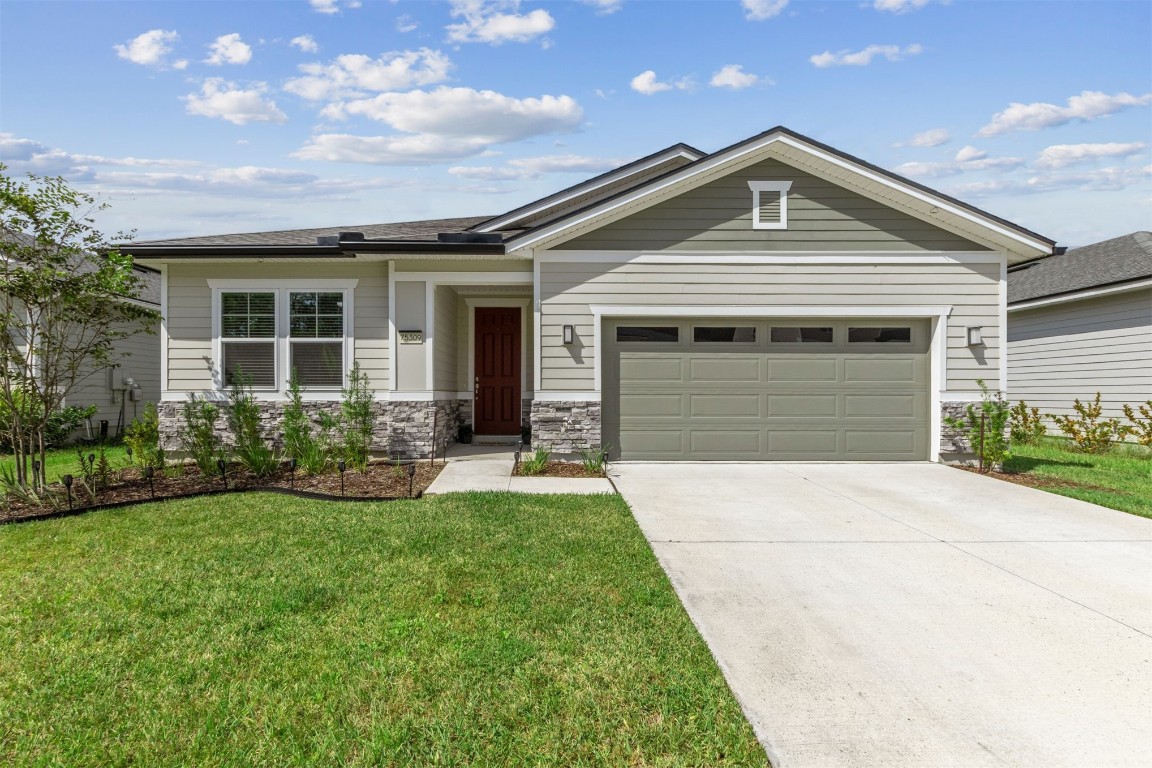 a front view of a house with a yard and garage