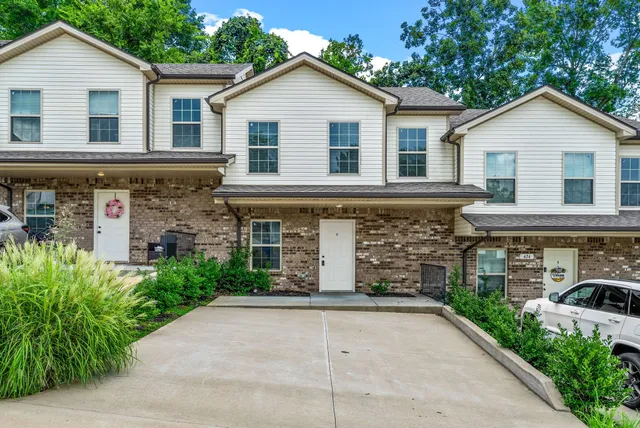 a view of a white house with large windows and a yard
