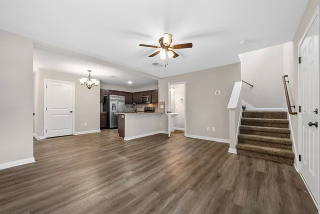 a view of a kitchen with wooden floor and a ceiling fan