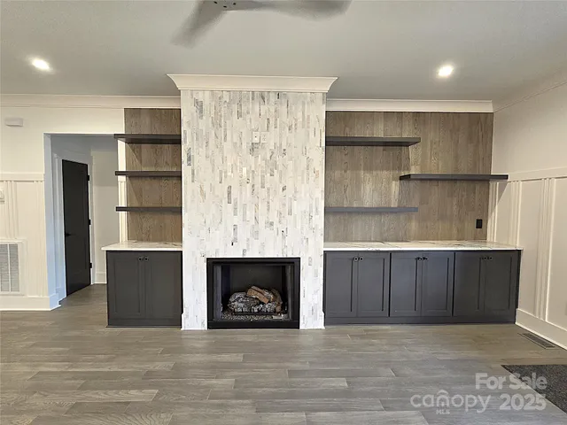 a view of kitchen and empty room with a fireplace