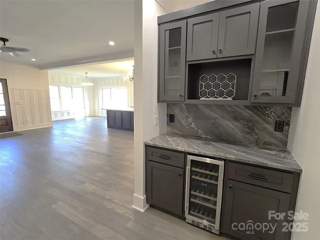 a living room with stainless steel appliances granite countertop a stove and a fireplace