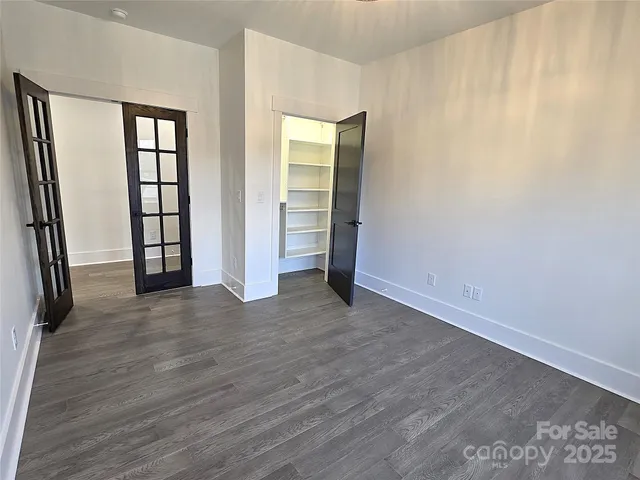 an empty room with wooden floor and entrance