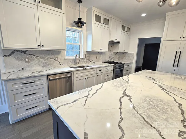 a kitchen with a sink a stove a refrigerator and cabinets