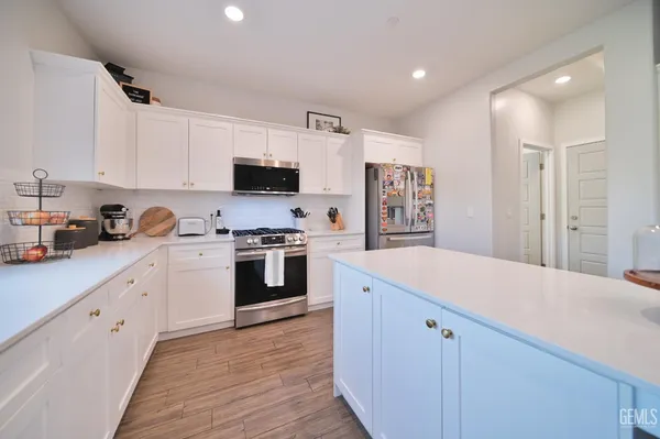 a kitchen with white cabinets and white appliances