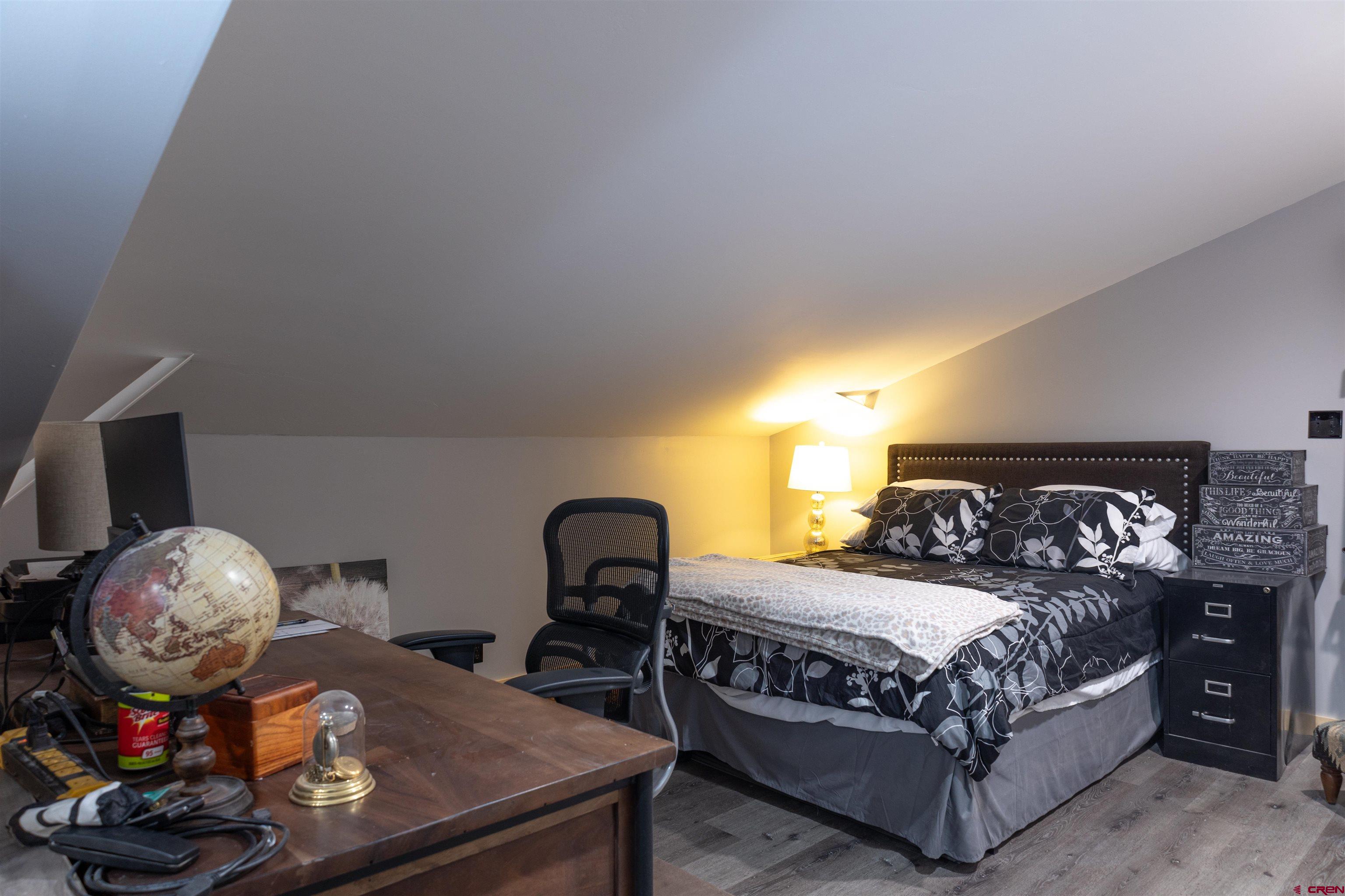 2632 Taylor Ranch Road Durango, CO 81301 - Photo 14 of 35 a bedroom with a bed a chandelier and dresser