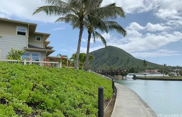a view of a house with a yard and potted plants