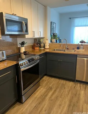 a kitchen with stainless steel appliances granite countertop a stove a sink and a microwave