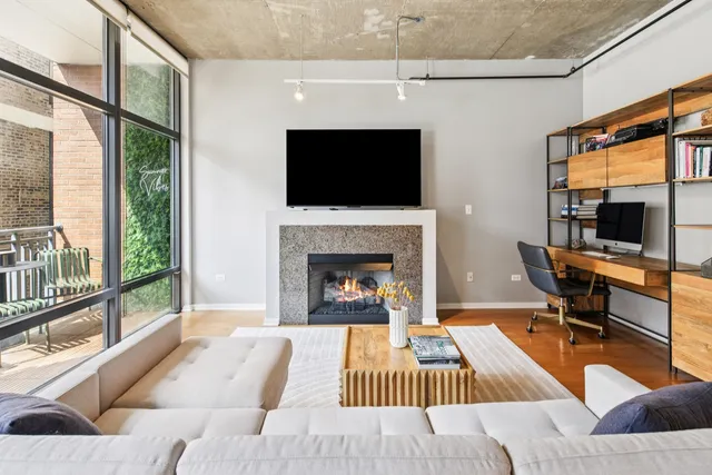 a living room with furniture a flat screen tv and a fireplace