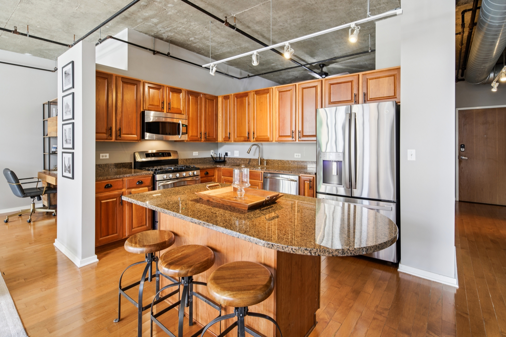 520 South State Street, Unit 816 Chicago, IL 60605 - Photo 6 of 15 a kitchen with stainless steel appliances granite countertop a refrigerator a stove a sink a dining table and chairs with wooden floor