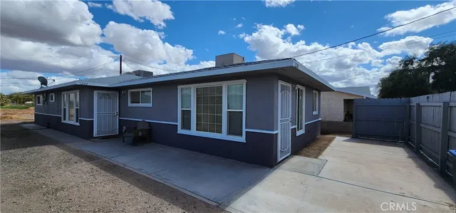 a view of a house with a large space and a large tree