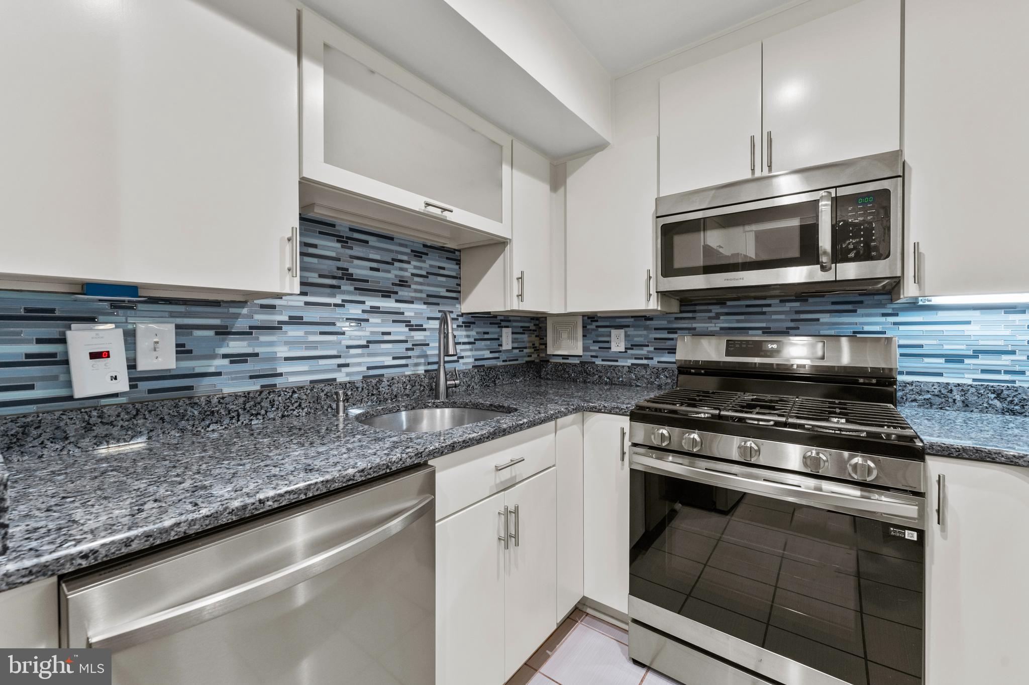 7541 Spring Lake Drive, Unit B1 Bethesda, MD 20817 - Photo 16 of 35 a kitchen with stainless steel appliances granite countertop a sink stove and microwave