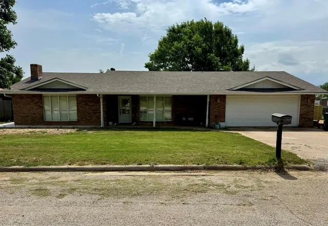 a front view of a house with a garden and yard
