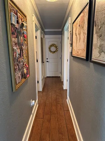 a view of a hallway with wooden floor and a painting on the wall