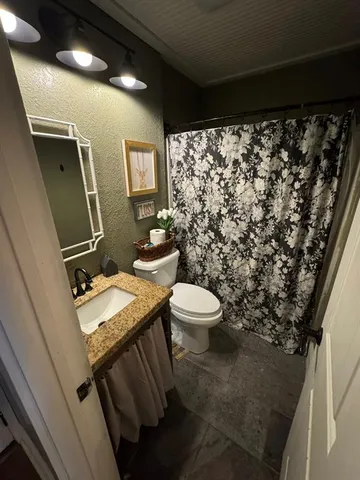 a bathroom with a sink toilet and a mirror