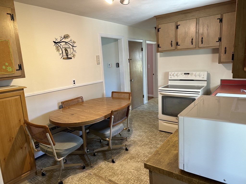 51 Prudential Road Worcester, MA 01606 - Photo 14 of 26 a kitchen with a table chairs and a refrigerator