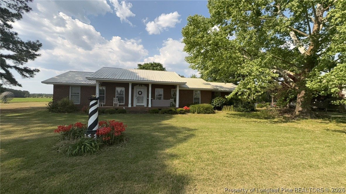 7939 Clinton Road Stedman, NC 28391 - Photo 1 of 50 a front view of a house with a garden