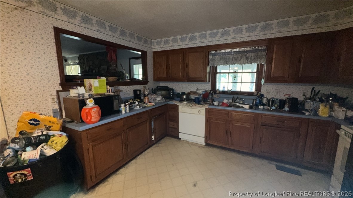 7939 Clinton Road Stedman, NC 28391 - Photo 12 of 50 a kitchen with granite countertop lots of clutter and cabinets