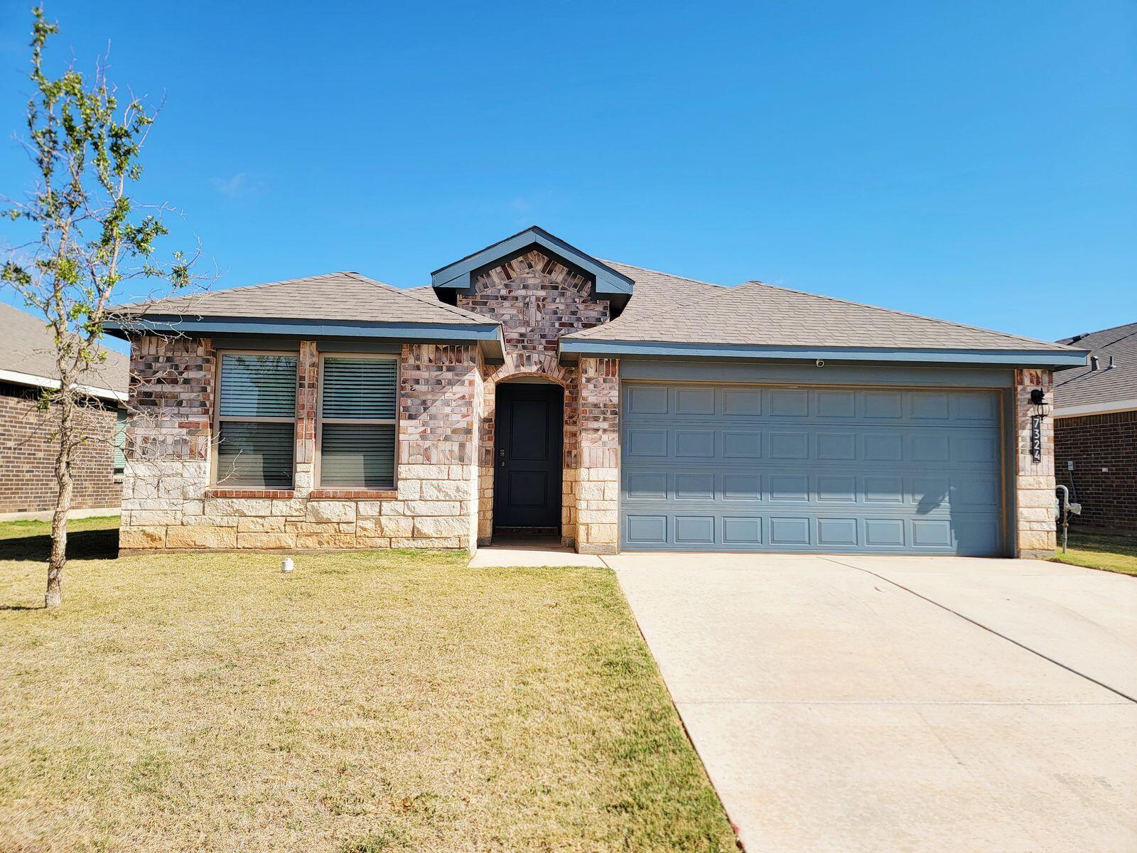 7324 9th Street Lubbock, TX 79416 - Photo 1 of 21 a front view of a house with a yard and garage