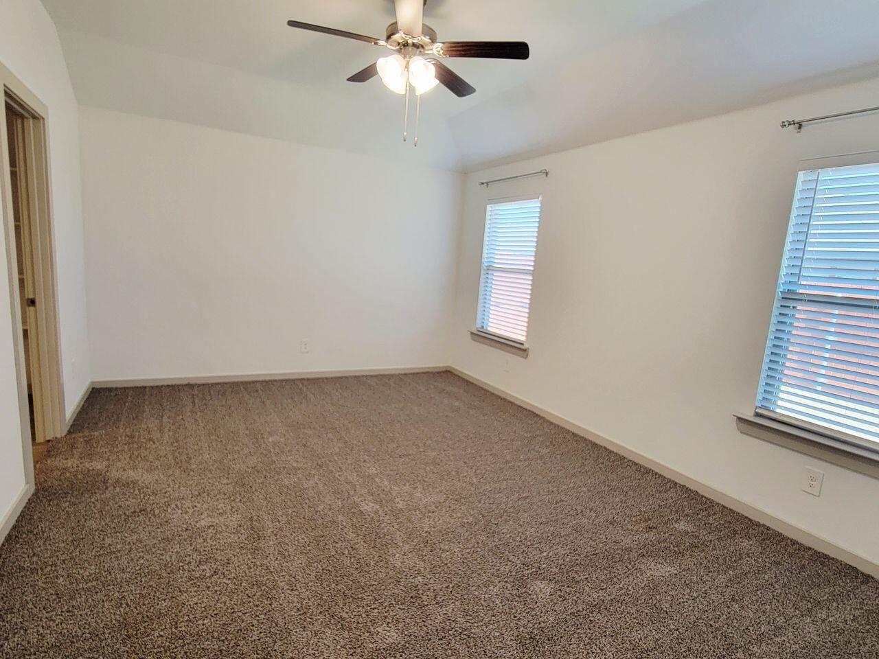 7324 9th Street Lubbock, TX 79416 - Photo 14 of 21 an empty room with windows and fan