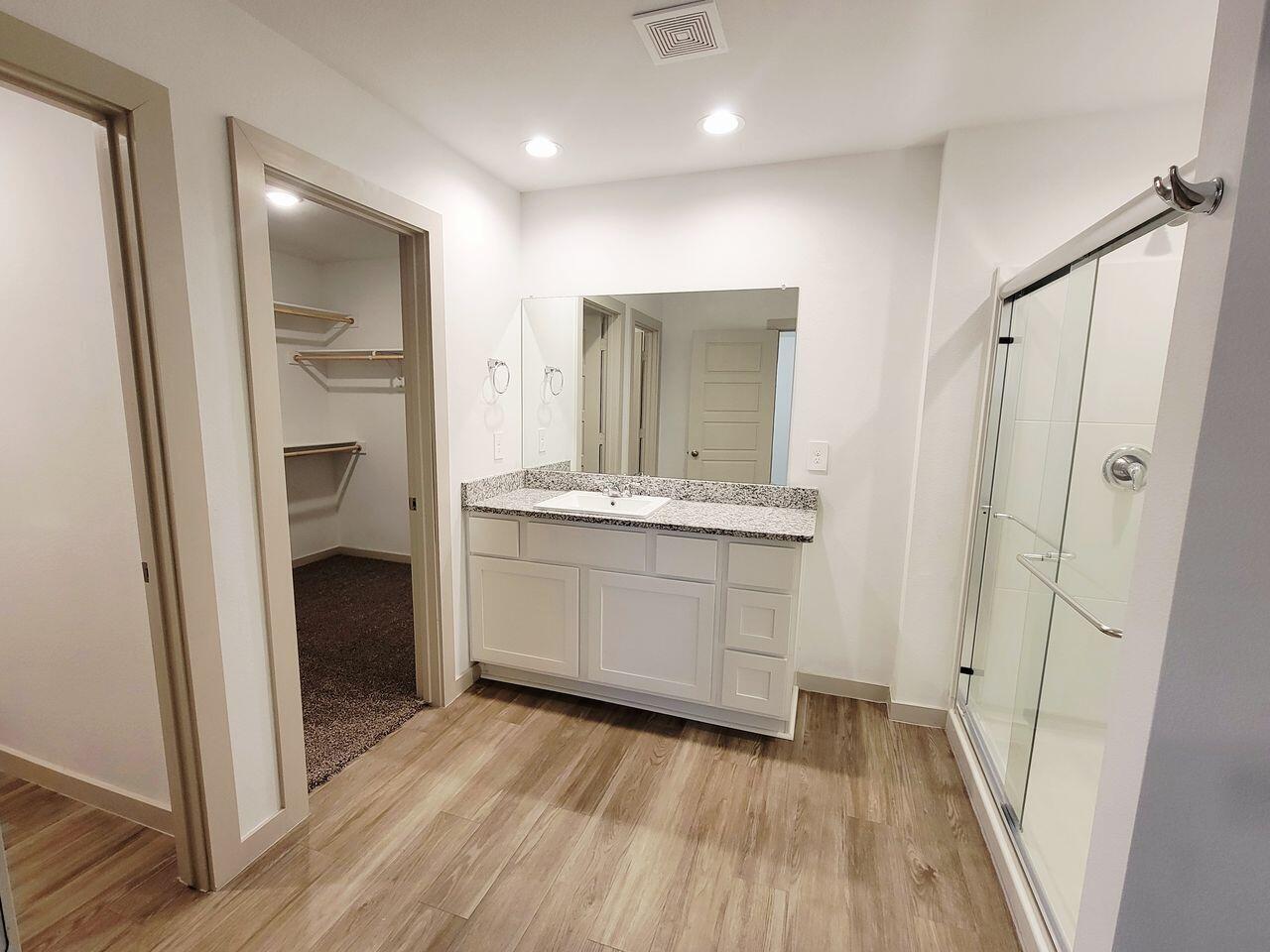 7324 9th Street Lubbock, TX 79416 - Photo 15 of 21 a bathroom with a double vanity sink and a mirror