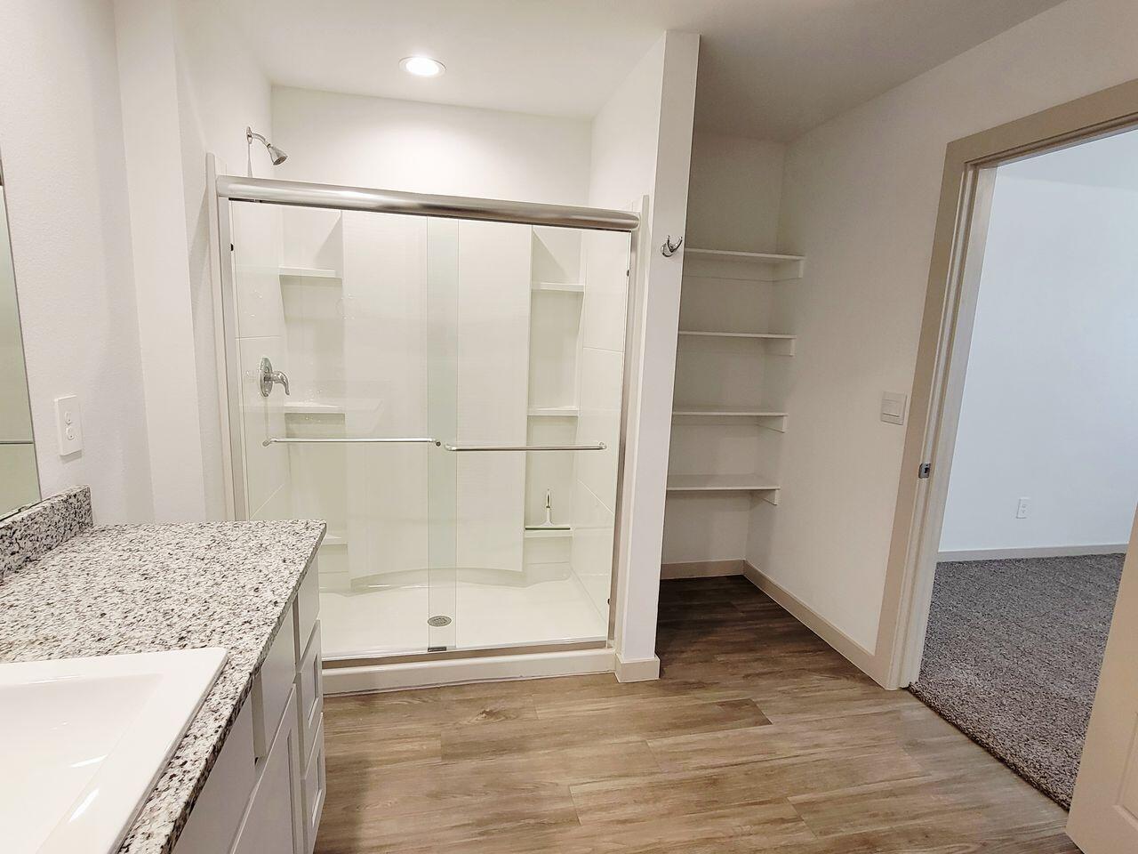 7324 9th Street Lubbock, TX 79416 - Photo 17 of 21 a bathroom with a granite countertop shower a sink and a mirror