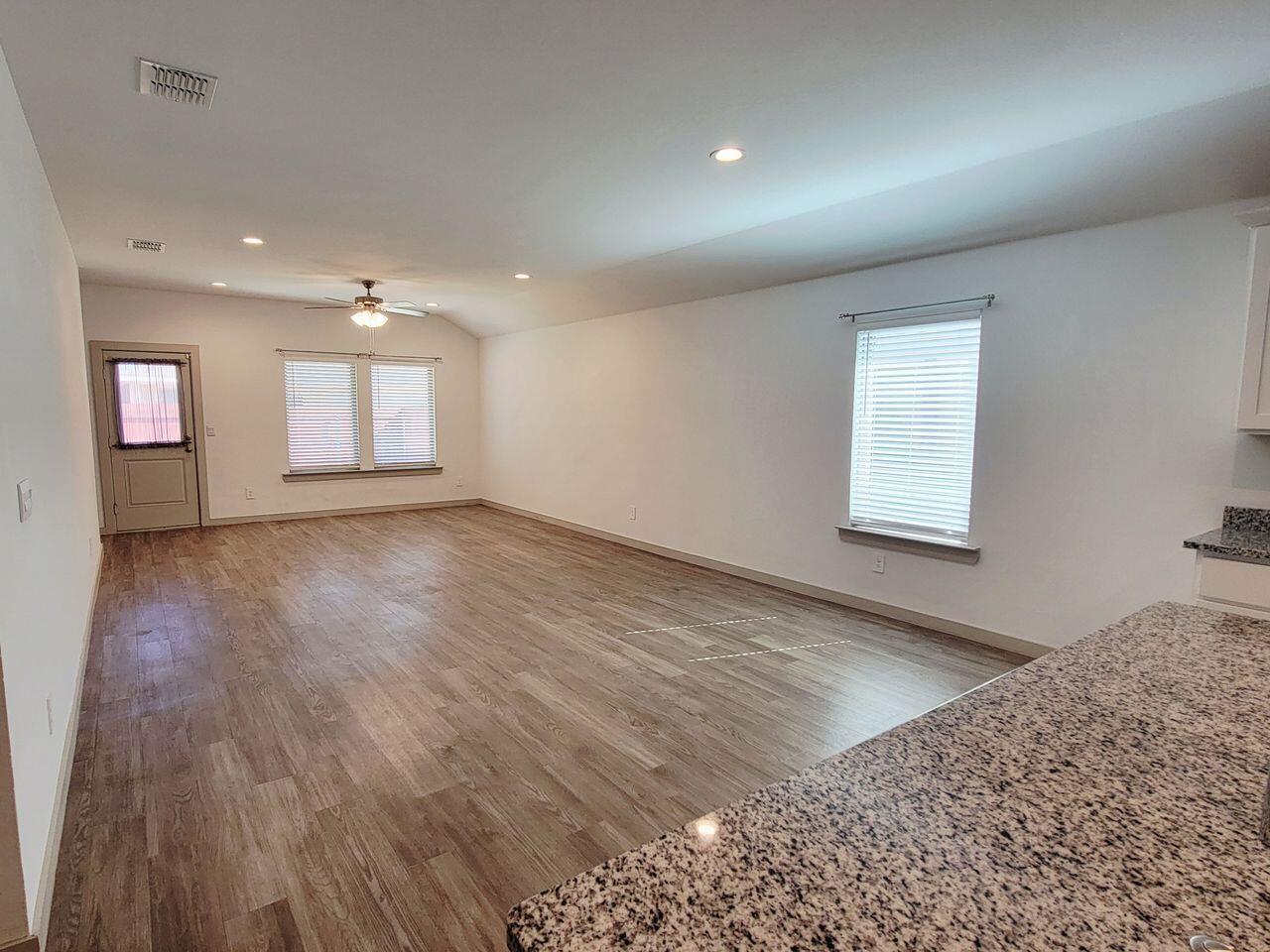7324 9th Street Lubbock, TX 79416 - Photo 5 of 21 an empty room with wooden floor and windows