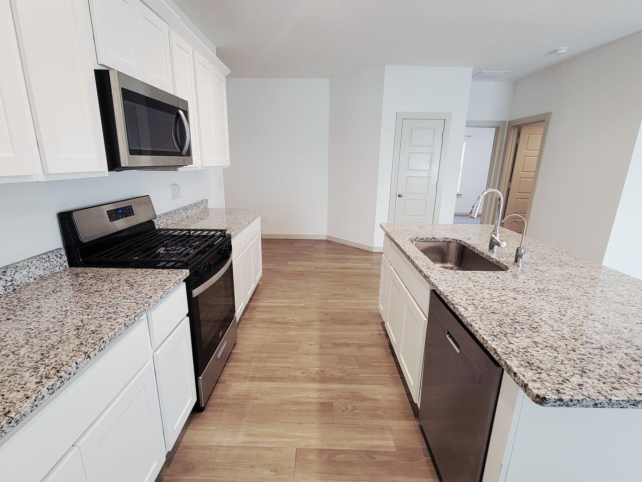 7324 9th Street Lubbock, TX 79416 - Photo 8 of 21 a kitchen with granite countertop sink stove and cabinets