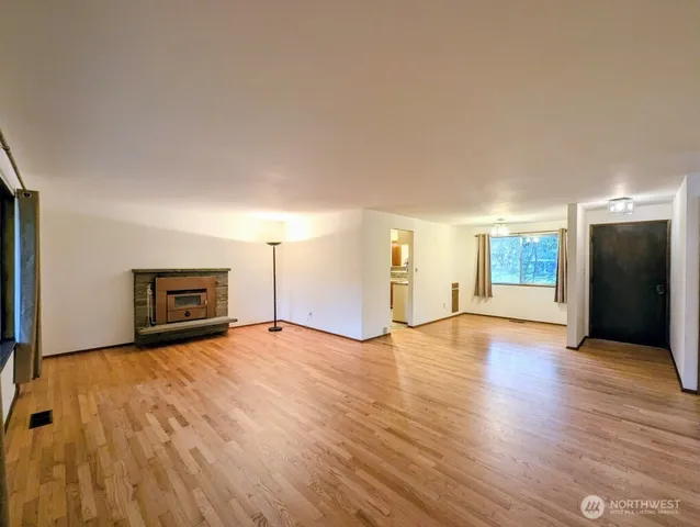 a view of empty room with wooden floor