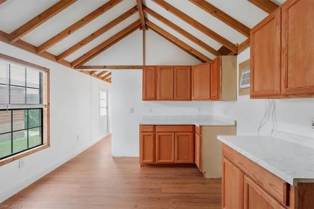 a kitchen with stainless steel appliances granite countertop a sink a stove cabinets and wooden floor