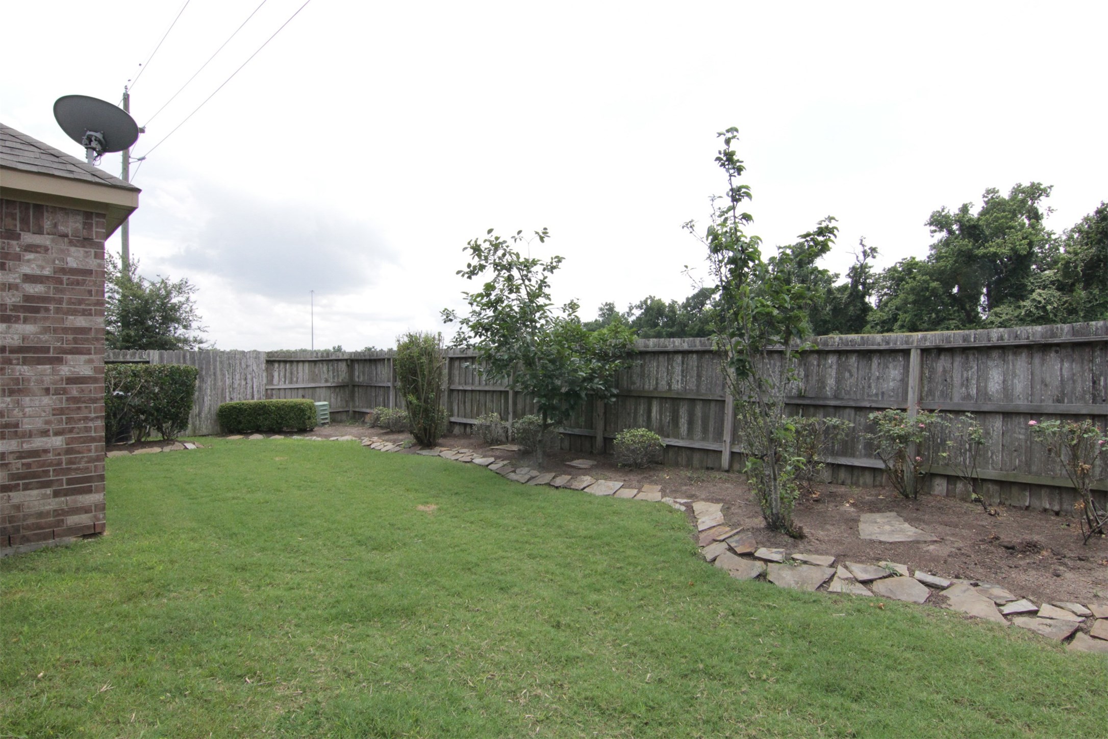 1423 Ralston Branch Way Sugar Land, TX 77479 - Photo 36 of 43 nice-size backyard with flower beds along fence surrounded by large pavers; no back neighbors!