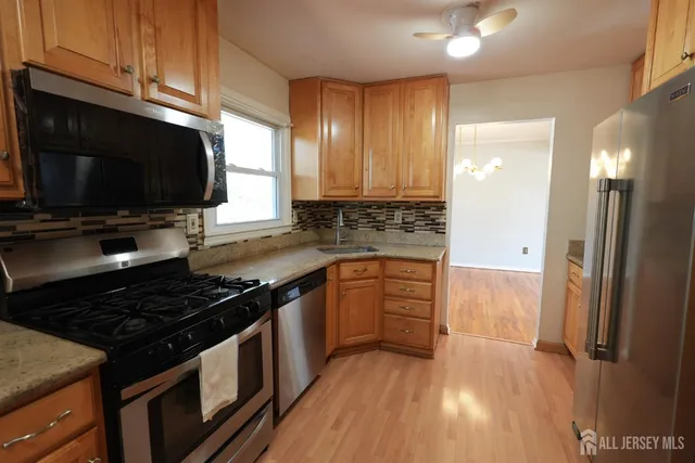 a kitchen with granite countertop a stove and a wooden cabinets