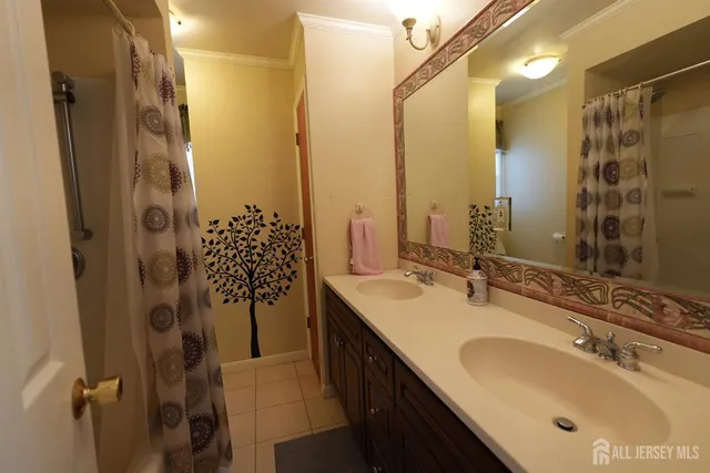 a bathroom with a double vanity sink mirror and shower