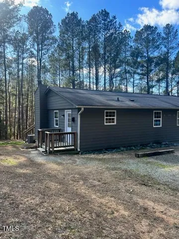 a view of a house with a yard and trees