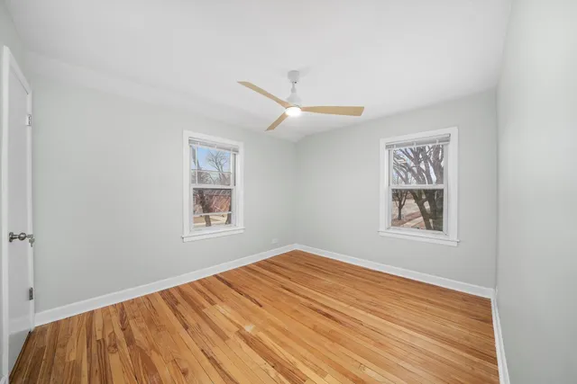 a view of a big room with wooden floor and a window
