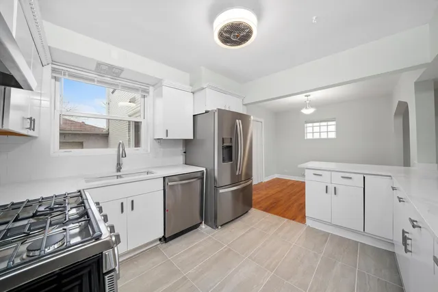 a kitchen with white cabinets and stainless steel appliances