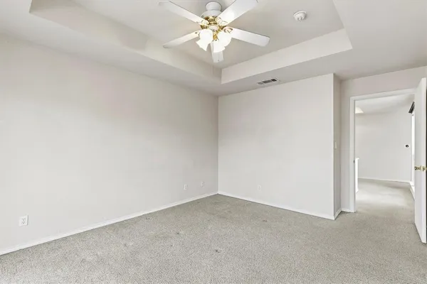 an empty room with a ceiling fan and a window