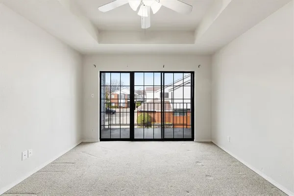 an empty room with a ceiling fan and a window