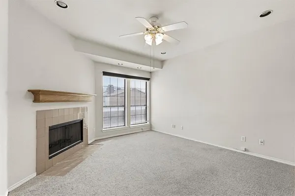 an empty room with fireplace and fan