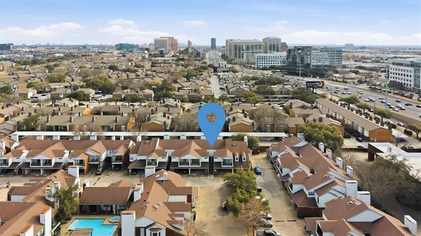 an aerial view of residential houses with outdoor space and parking