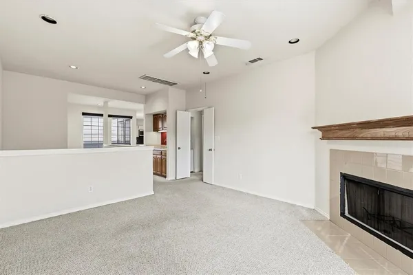 a view of a kitchen with furniture a fireplace and a ceiling fan