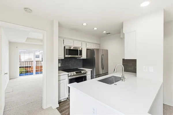 a kitchen with stainless steel appliances a refrigerator stove microwave and sink