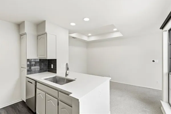 a kitchen with a sink and white cabinets