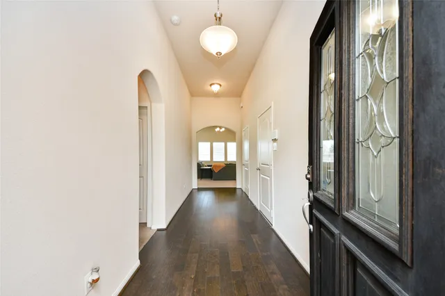 a view of a hallway with wooden floor and staircase